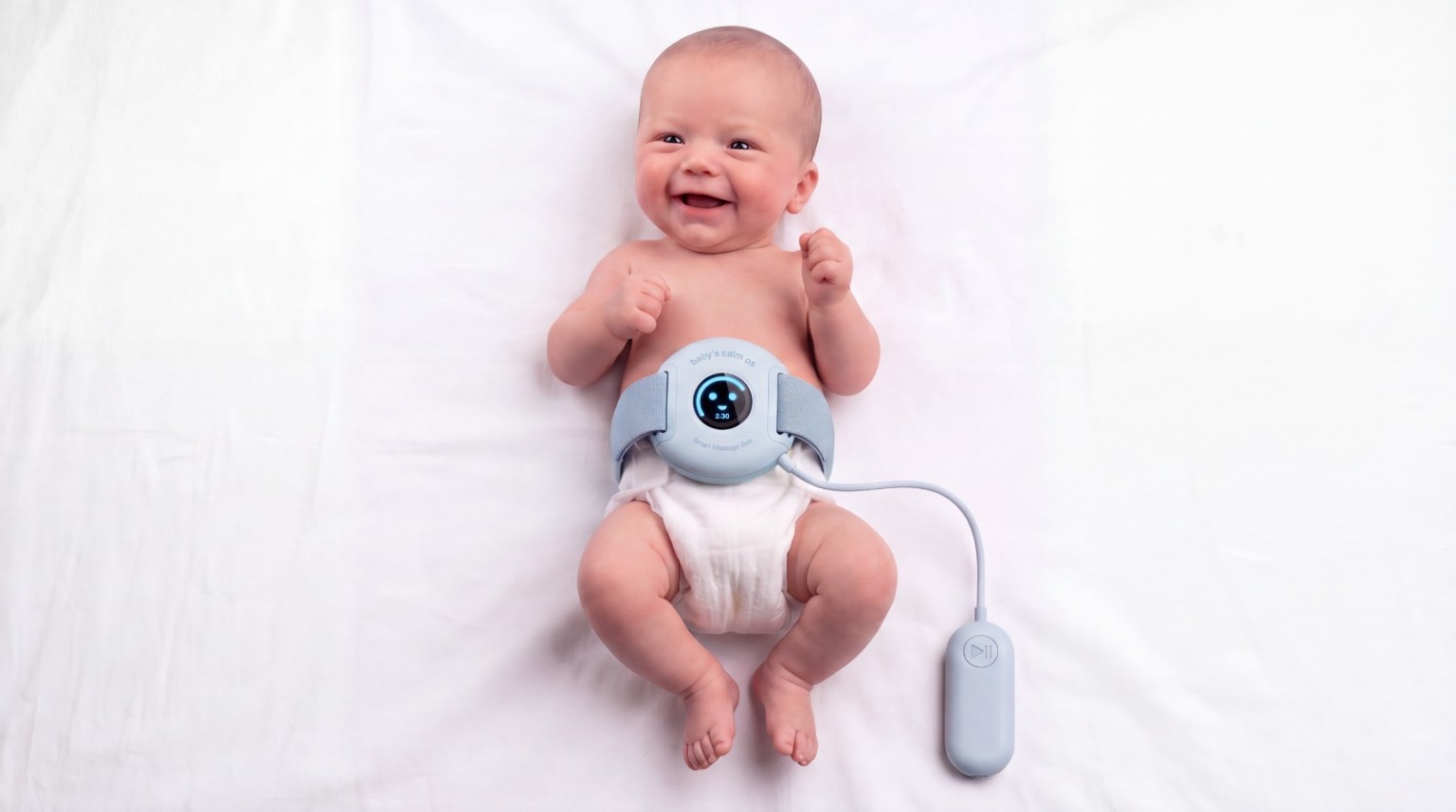 Smiling baby wearing the blue Baby’s Calm OS belt with its separate controller
